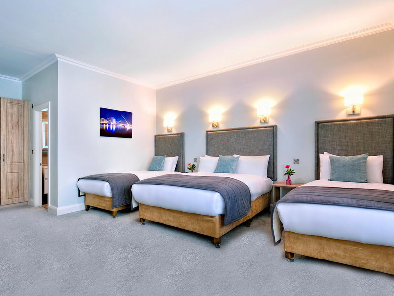Large bedroom at Sandymount Hotel with two double beds and one single bed